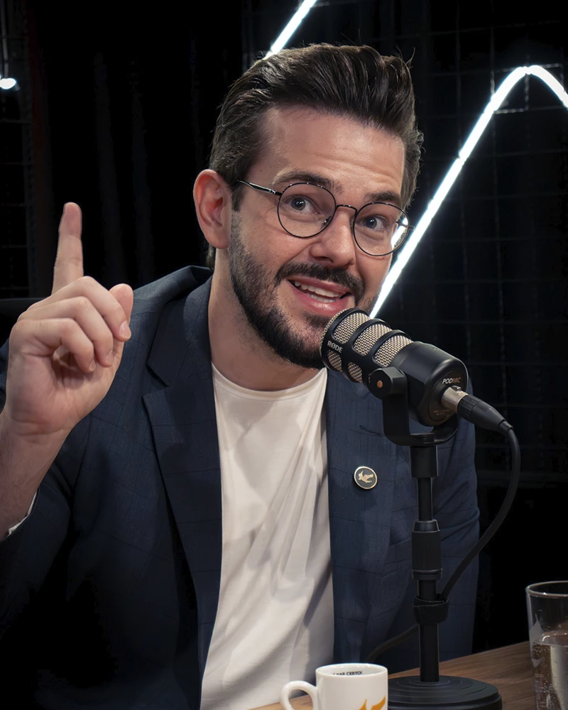 Renan Nicolini durante a gravação de um podcast, gesticulando enquanto fala ao microfone